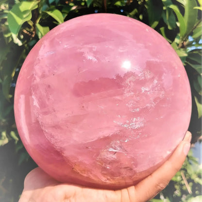 A large rose quartz crystal ball - a deep pink bohemian sphere, perfect for weddings and Valentine's Day decorations.